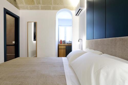 a bedroom with a large bed with blue cabinets at Mazzini Accommodation in Favignana
