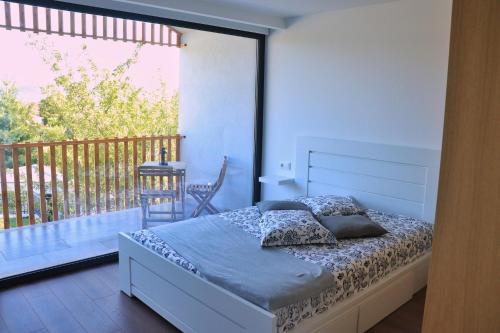 een slaapkamer met een bed en een balkon bij Casa João Eusébio 2 in Ponte de Lima