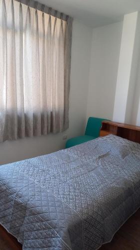 a bedroom with a bed and a window at Hospedaje Margarita in La Merced