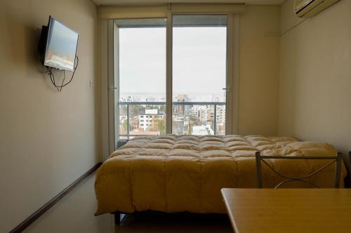 a bedroom with a bed and a large window at Caviahue 328 in Neuquén