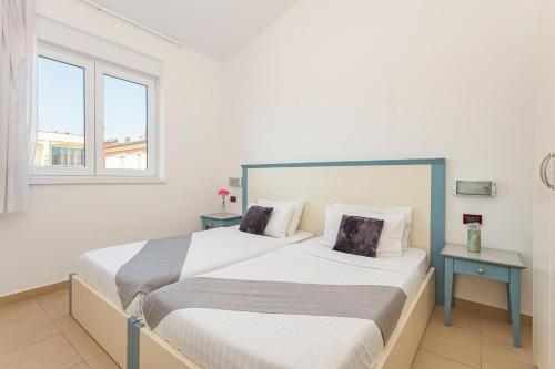 Residence Superior Del Mar في بولا: سريرين في غرفة بها نافذتين
