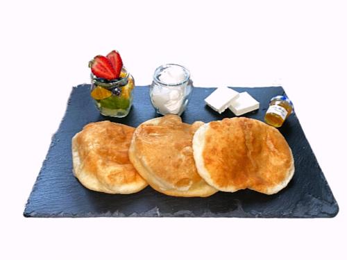 two pancakes on a black plate with butter and syrup at The Wind Mills Hydropark in Gorna Malina