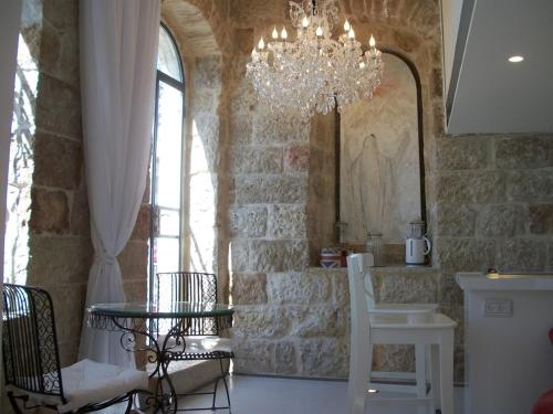 a dining room with a chandelier and a table and chairs at The White House Jerusalem סוויטת הבית הלבן ירושלים in Jerusalem
