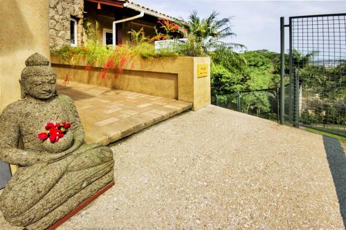 a statue of a woman holding a flower on a patio at Studios Altos da Igrejinha in Florianópolis