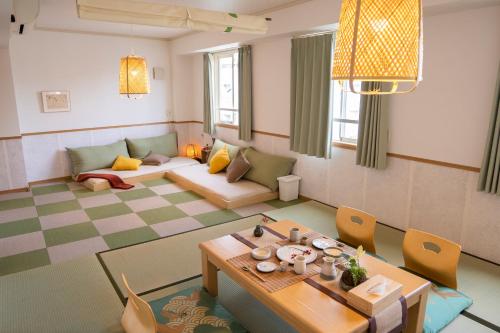ein Wohnzimmer mit einem Tisch und einem Sofa in der Unterkunft 久Hisashi新栄店民泊 in Nagoya