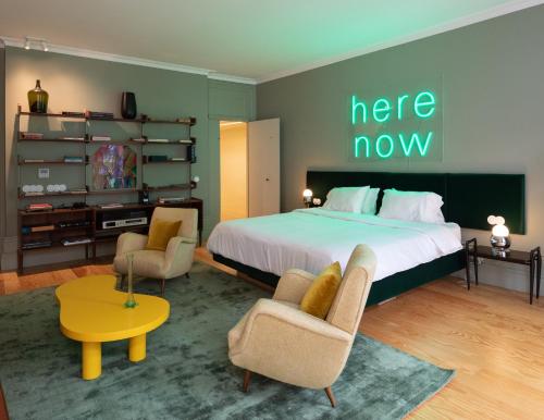 a bedroom with a bed with a here now sign on the wall at Almadina Smart Luxury in Porto