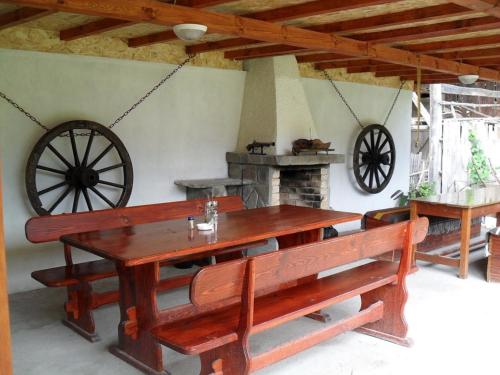 a wooden table and benches in a room with a fireplace at Roden Dom Holiday Home in Apriltsi