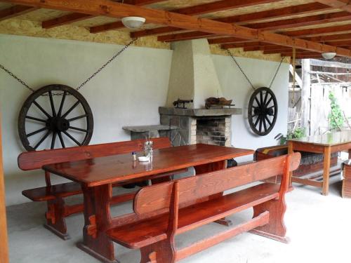 una mesa de madera y bancos en una habitación con chimenea en Roden Dom Holiday Home, en Apriltsi