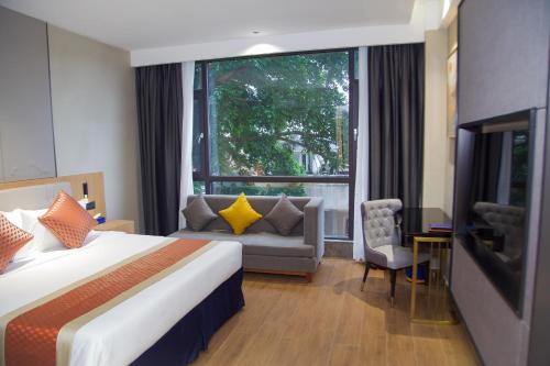 a hotel room with a bed and a couch and a window at Hôtel FAMILLE MONDIALE in Abidjan