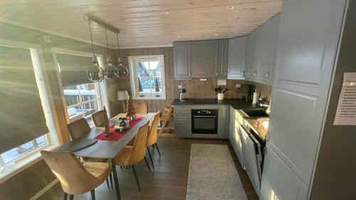 a kitchen with a table and some chairs in it at Sanderstølen Hytter in Sanderstølen