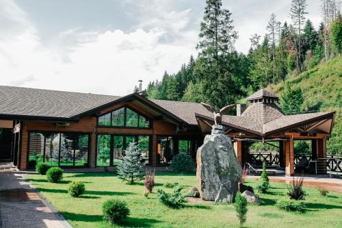 een blokhut met een grote rots in de tuin bij Готель Жди ня Єво instagram zhdenievo hotel in Zhdenievo