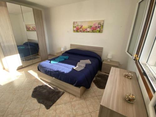 1 dormitorio con cama azul y espejo en CASA VISTA MARE - Superb garden and Parking included, en Imperia