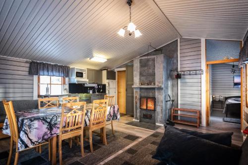 a dining room with a table and a fireplace at Koivuranta in Räätäniemi
