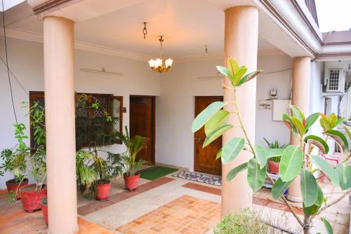 a lobby with columns and potted plants at Malaiya Homestay - Grandeur Living Experience in Jabalpur