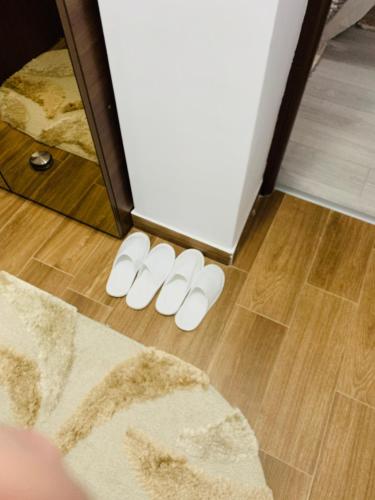 a pair of white slippers on the floor in a room at Garsoniera lux centru pietonal Tîrgu - Jiu in Târgu Jiu