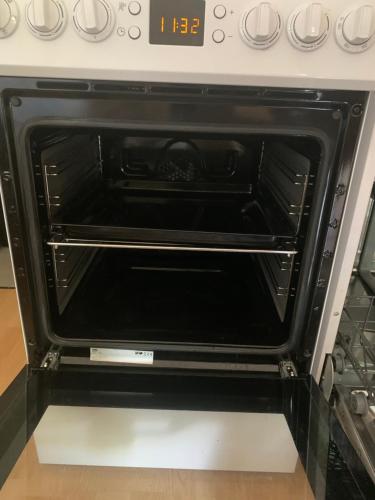 an oven with the door open in a kitchen at Ski-to-door apartment au Collet d'Allevard in Allevard