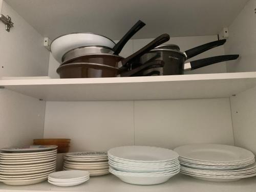 a bunch of plates and pans on a shelf at Ski-to-door apartment au Collet d'Allevard in Allevard