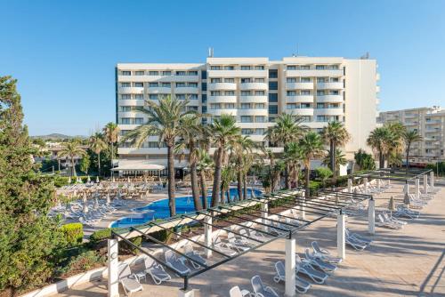 un resort con sedie, una piscina e un edificio di Welikehotel Marfil Playa a Sa Coma
