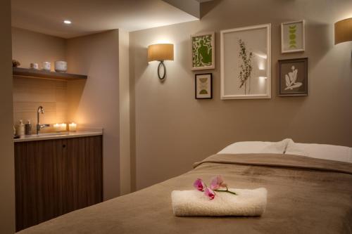a bed with a towel with a flower on it at Taplow House Hotel & Spa in Maidenhead