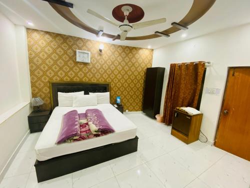 a bedroom with a large white bed in a room at Hotel Mehran Multan in Multan