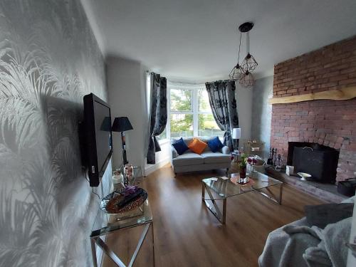 a living room with a couch and a fireplace at 2 bed apartment 5min from sea in bare Morecombe in Morecambe