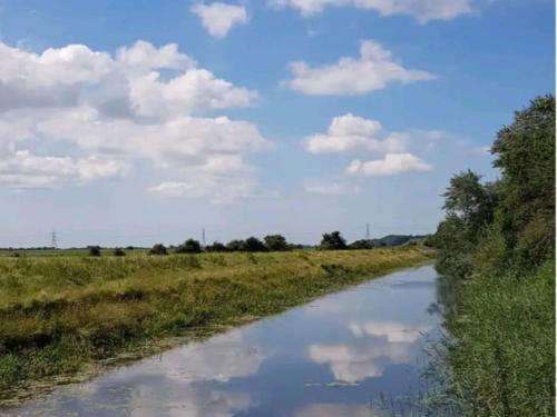 a river in the middle of a field at Pass the Keys Fabulous Beach Front Holiday Location in Lydd
