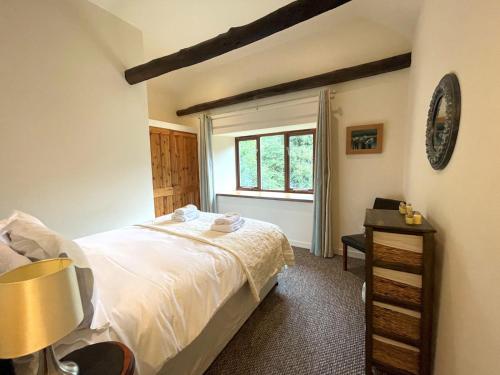 a bedroom with a bed and a window at Pass the Keys Beautiful 2BR Converted Mill - Idyllic Location in Dumfries