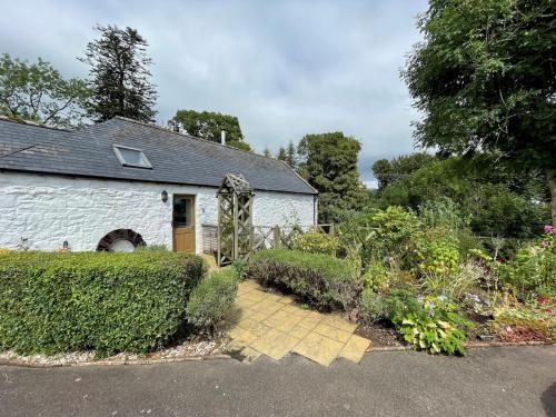 a white house with a garden in front of it at Pass the Keys Beautiful 2BR Converted Mill - Idyllic Location in Dumfries