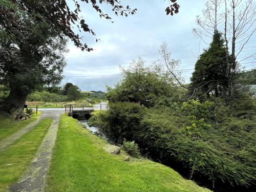 a path next to a river with a bridge at Pass the Keys Beautiful 2BR Converted Mill - Idyllic Location in Dumfries