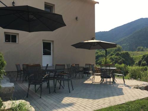 een patio met tafels, stoelen en parasols bij Aleu - Apuseni Mountains in Pietroasa