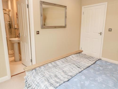 sypialnia z lustrem na ścianie i łóżkiem w obiekcie Calm Skies w mieście Berwick-upon-Tweed