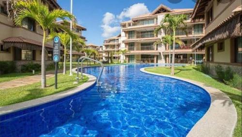 a large blue swimming pool in front of a building at Manhattan Riviera Beach in Aquiraz