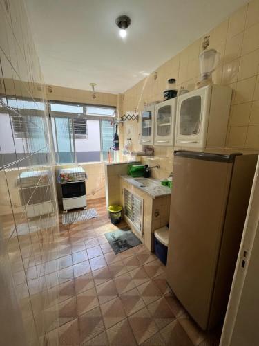 uma cozinha com um frigorífico e um lavatório em Apartamento no CENTRO de Caraguatatuba. em Caraguatatuba