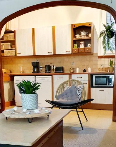 une cuisine avec une table et une chaise sur un comptoir dans l'établissement La Galine, Maison de village medieval, à Lunas