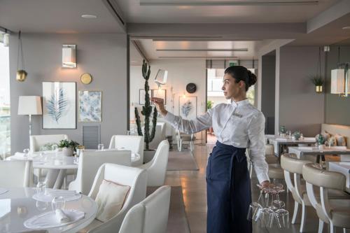 una mujer parada en un comedor en Hotel Excelsior en Pesaro