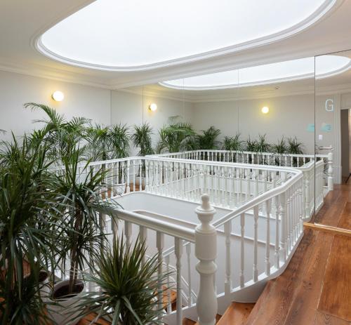 Una escalera blanca con plantas en una habitación con techo en Almadina Smart Luxury, en Oporto