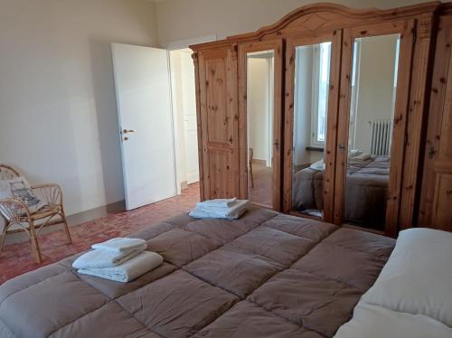 1 dormitorio con 1 cama grande y toallas. en Rifugio escursionistico ex-scuola Grassi, Bubbio, en Bubbio