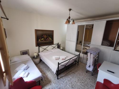 a small room with two beds and a tv at Home Egitto 53 in Modica