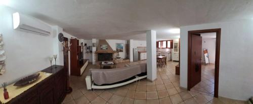 sala de estar amplia con sofá y cocina en Accogliente seminterrato a due passi dal mare, en Golfo Aranci