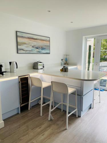 a kitchen with a counter with two chairs and a table at Hampton Vale, Peterborough Lakeside Large Double bedroom with own bathroom in Peterborough