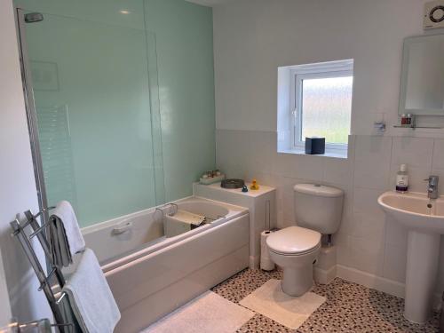 y baño con bañera, aseo y lavamanos. en Hampton Vale, Peterborough Lakeside Large Double bedroom with own bathroom en Peterborough