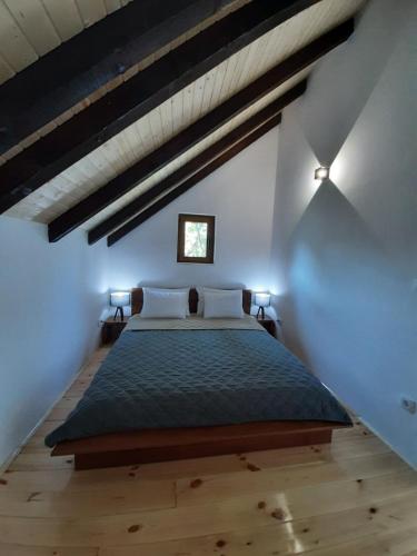 a bedroom with a large bed in a attic at Fern Farm Eco Studio Apartment in Mojkovac
