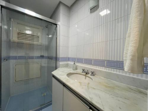 a bathroom with a sink and a shower at Apartamento a 100m da Rua Coberta in Gramado