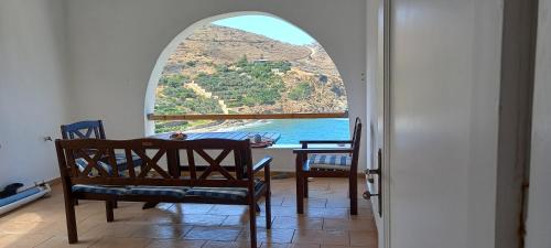 a room with a table and chairs and a window at Balcony to Aegeon 1 in Apollon