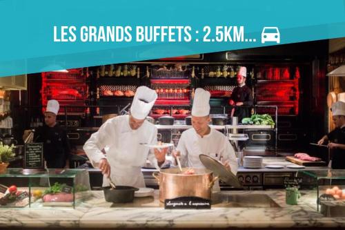 dos chefs están preparando comida en una cocina en Le Lovely Narbonnais - Balneo & Sauna, en Narbona