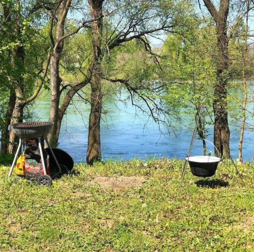 a grill sitting next to a body of water at Vikendica Drina Hill Loznica in Loznica