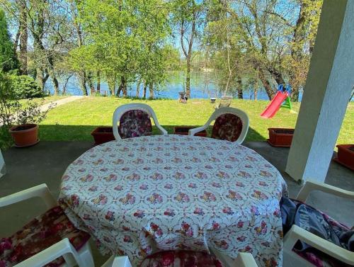 a table and chairs on a patio with a view of a park at Vikendica Drina Hill Loznica in Loznica