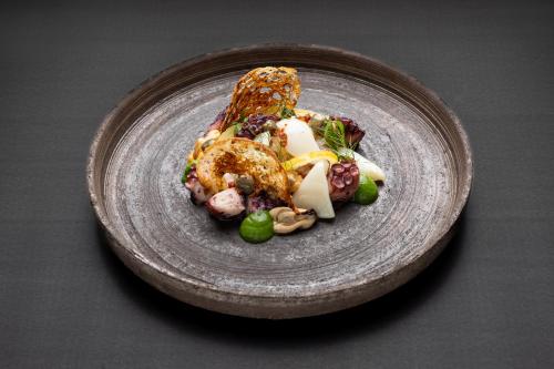 a gray plate with food on a table at Habitat Boutique Hotel in Catania