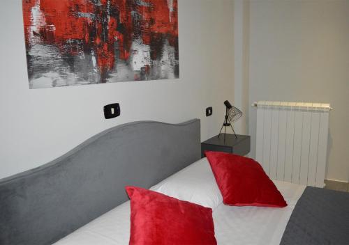 AquinoにあるB&B Aquino in Terrazzaのベッドルーム1室(赤い枕と絵画付)