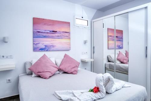 sypialnia z łóżkiem z różowymi poduszkami w obiekcie Los Molinos Luxury y Relax w Costa Teguise